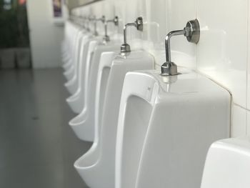 Close-up of urinals in bathroom
