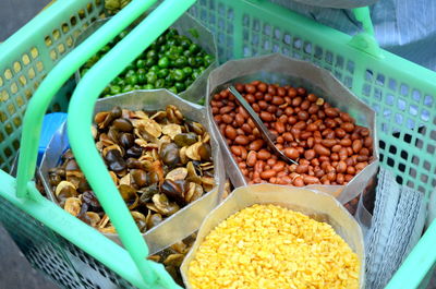 High angle view of person with seeds in plastic container at market