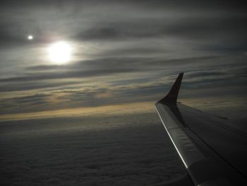 Cropped image of airplane against cloudy sky