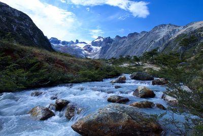 Scenic view of river amidst mountains against sky