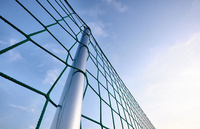 Low angle view of wind turbines against sky