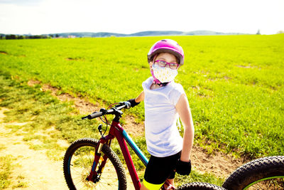 Portrait of boy riding bicycle on field