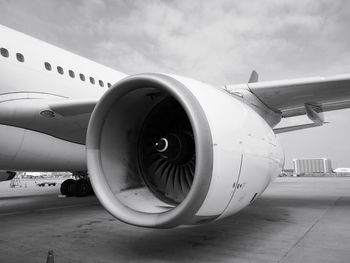 Close-up of airplane on airport runway against sky