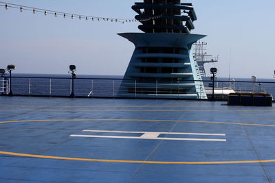 Pedestrian walkway by sea against clear sky