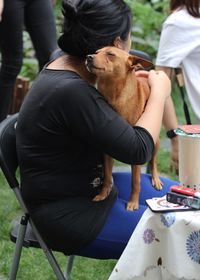 Woman sitting with dog in lap
