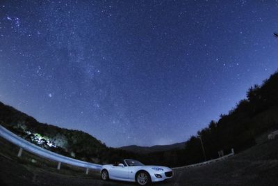 Cars on field against sky at night