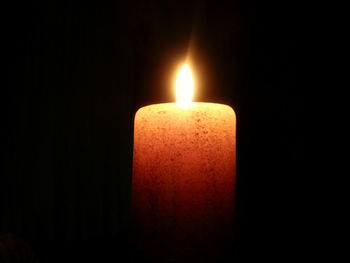 Close-up of burning candle in darkroom