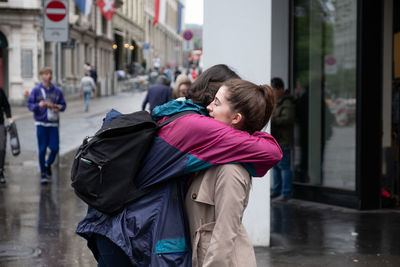 Rear view of people walking in rain