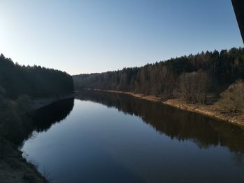 Scenic view of lake in forest against clear sky