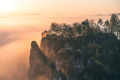 Rock formation against sky during sunset