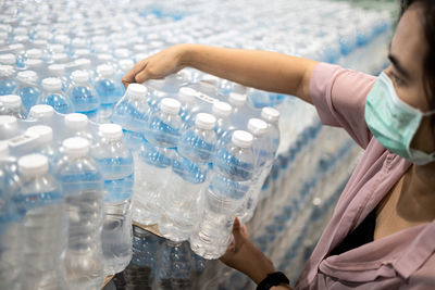 Midsection of woman holding glass bottle