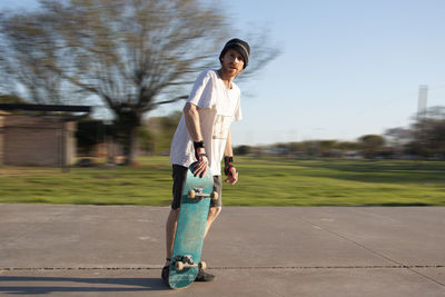 Portrait of skateboarder standing in skate park