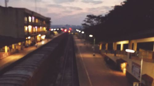 Close-up of illuminated railroad tracks against sky at night