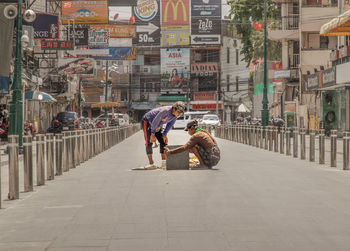 People sitting on street in city