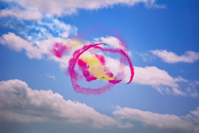 Low angle view of pink flying in sky