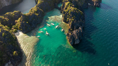 Tourist boats over tropical lagoon and coral reef, aerial view.el nido, philippines, palawan. 