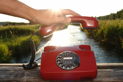 Close-up of hand holding red telephone receiver