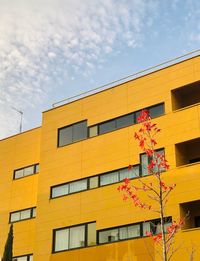 Low angle view of yellow building against sky