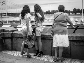 Side view of friends standing in city