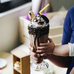 Cropped mother and child holding milkshake