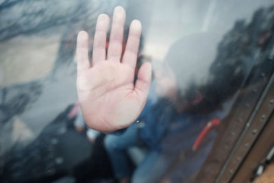 High angle view of boy touching window in vehicle