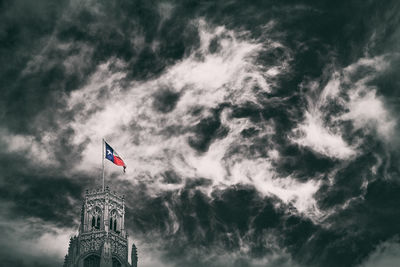 Low angle view of people against cloudy sky