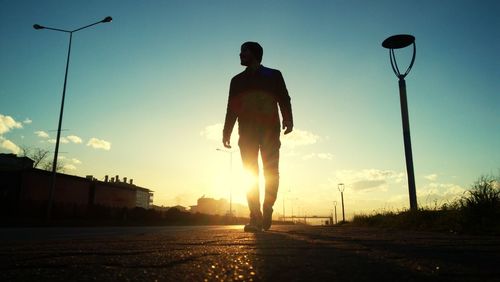 Low angle view of silhouette man against sky during sunset