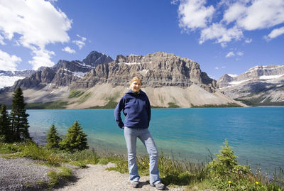 Full length of woman standing by bow lake against mountain at banff national park