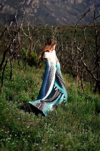 Full length of girl with blanket standing on field