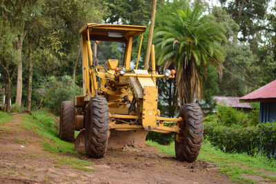 View of tractor on road by trees