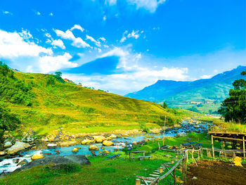 Scenic view of landscape and mountains against blue sky