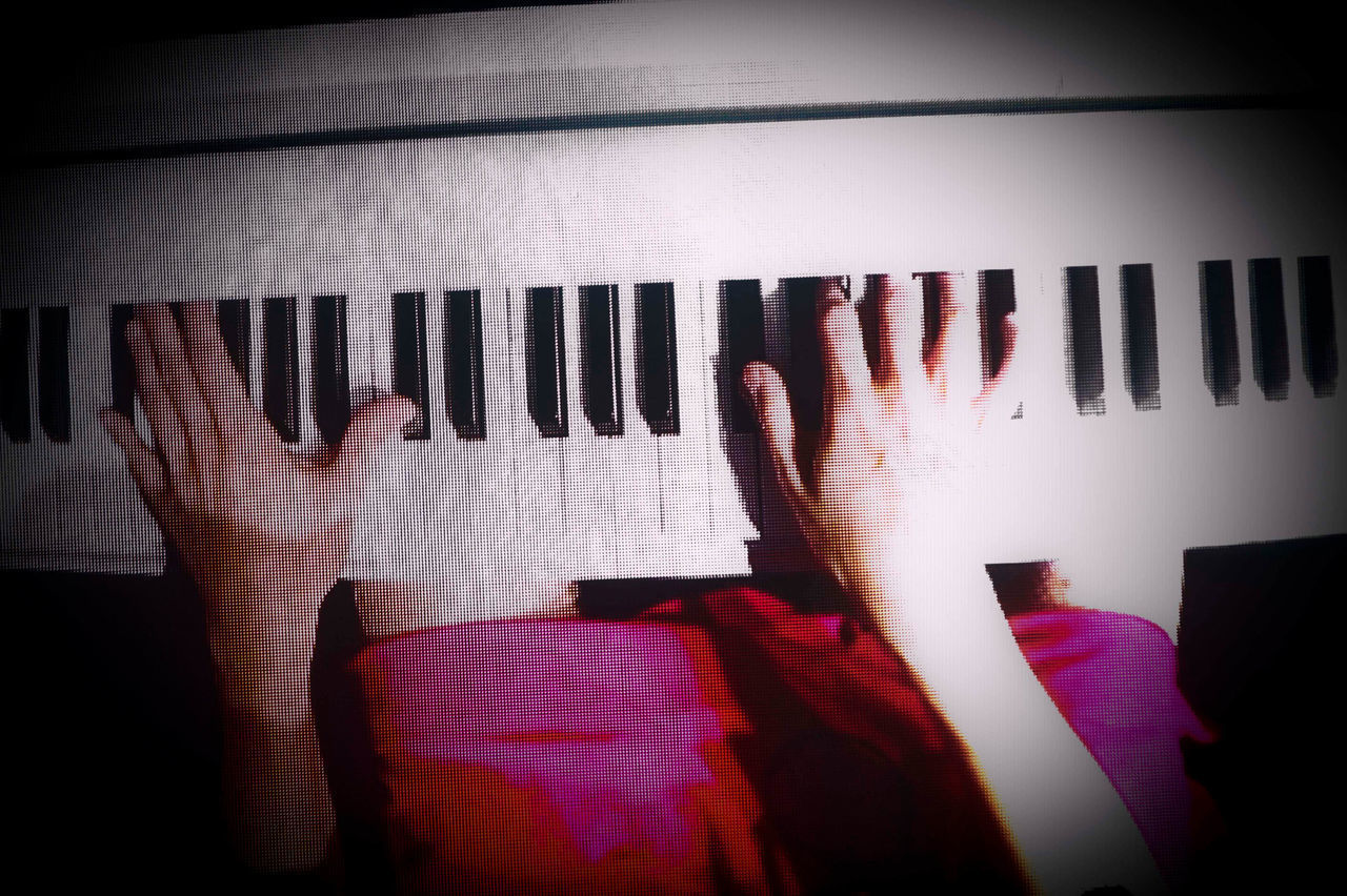 LOW ANGLE VIEW OF PERSON PLAYING PIANO AT HOME