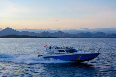 Boat in sea against sky during sunset