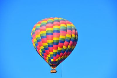 Hot air balloon floating on isolated blue sky 
