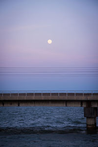 Pier over sea against sky during sunset