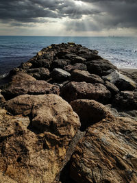 Scenic view of rocks on beach against sky