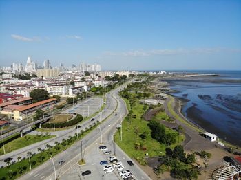 High angle view of city by sea against sky