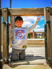 Portrait of boy standing on wood