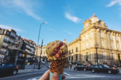 Close-up of hand holding ice cream on street