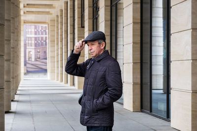 Side view of young man standing in city