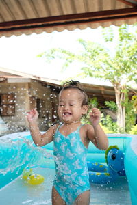 Happy girl playing in swimming pool