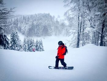 Rear view of man on snowboard during winter