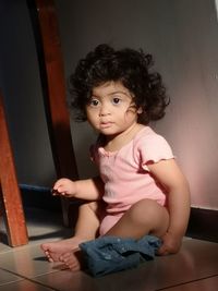 Portrait of cute baby girl sitting at home