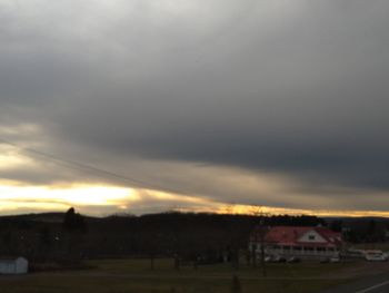 Houses and buildings against sky at sunset