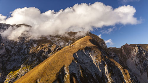 Low angle view of clouds over mountains