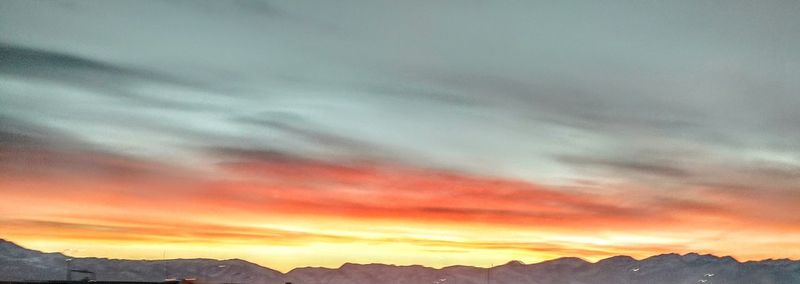 Scenic view of mountains against sky at sunset