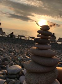 Stack of stones on beach during sunset