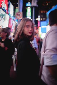 Young women standing in city at night