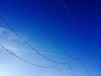 Low angle view of barbed wire against clear blue sky