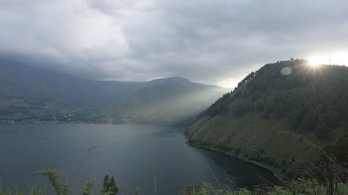 Scenic view of lake and mountains against sky